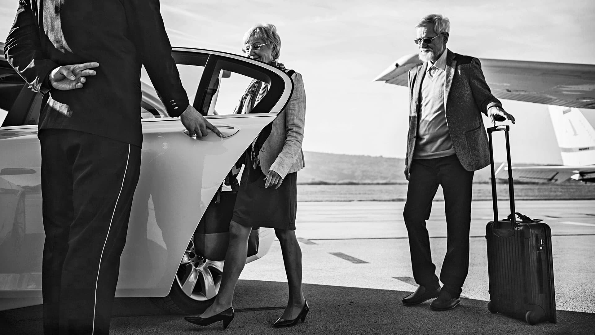 Professional chauffeur assisting airport travelers